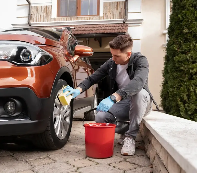 Lavage auto à domicile Rossfeld : professionnel intervenant sur un véhicule